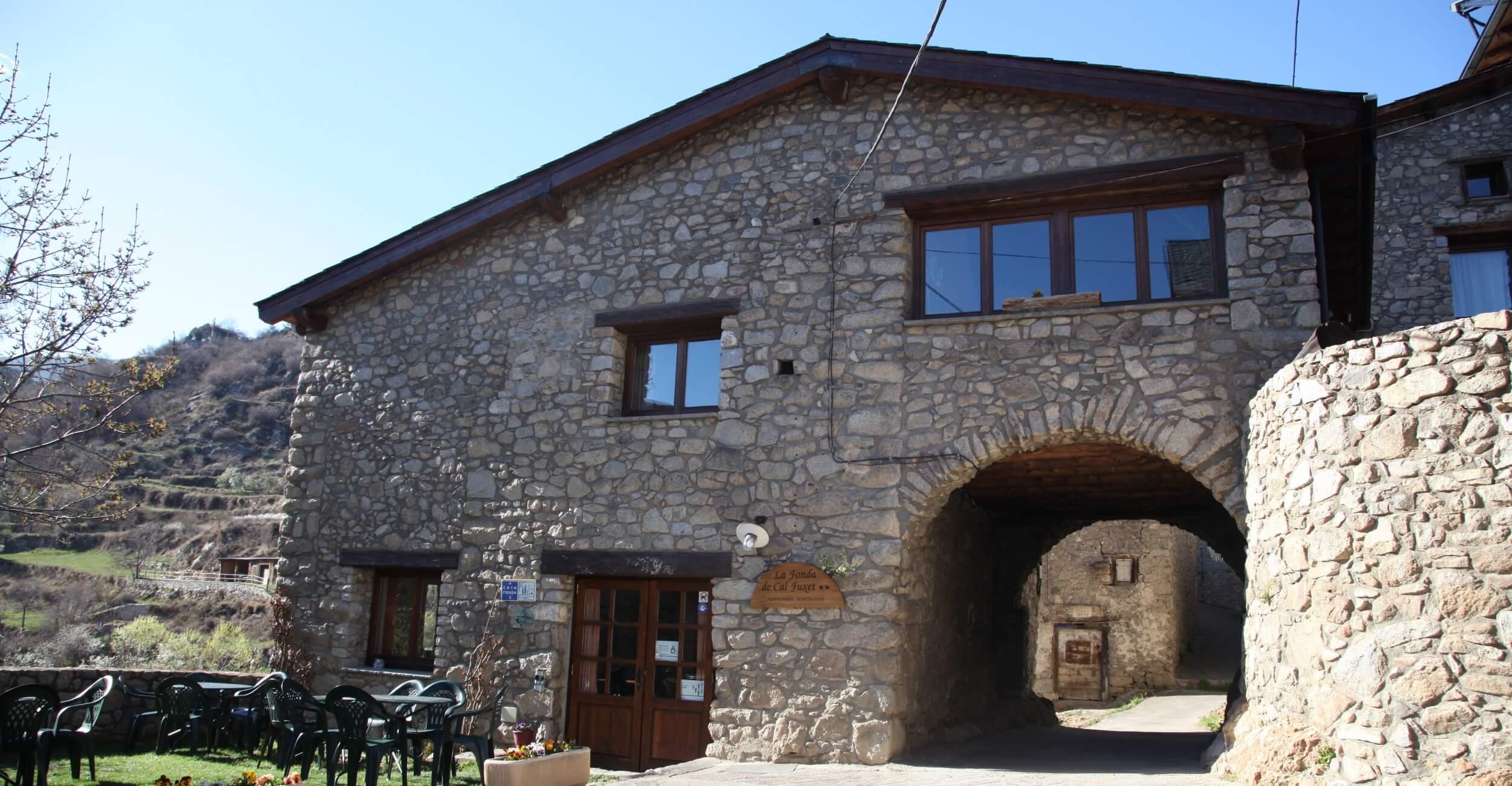 Façana de pedra i porxo de la Fonda de Cal Fuxet a Aransa